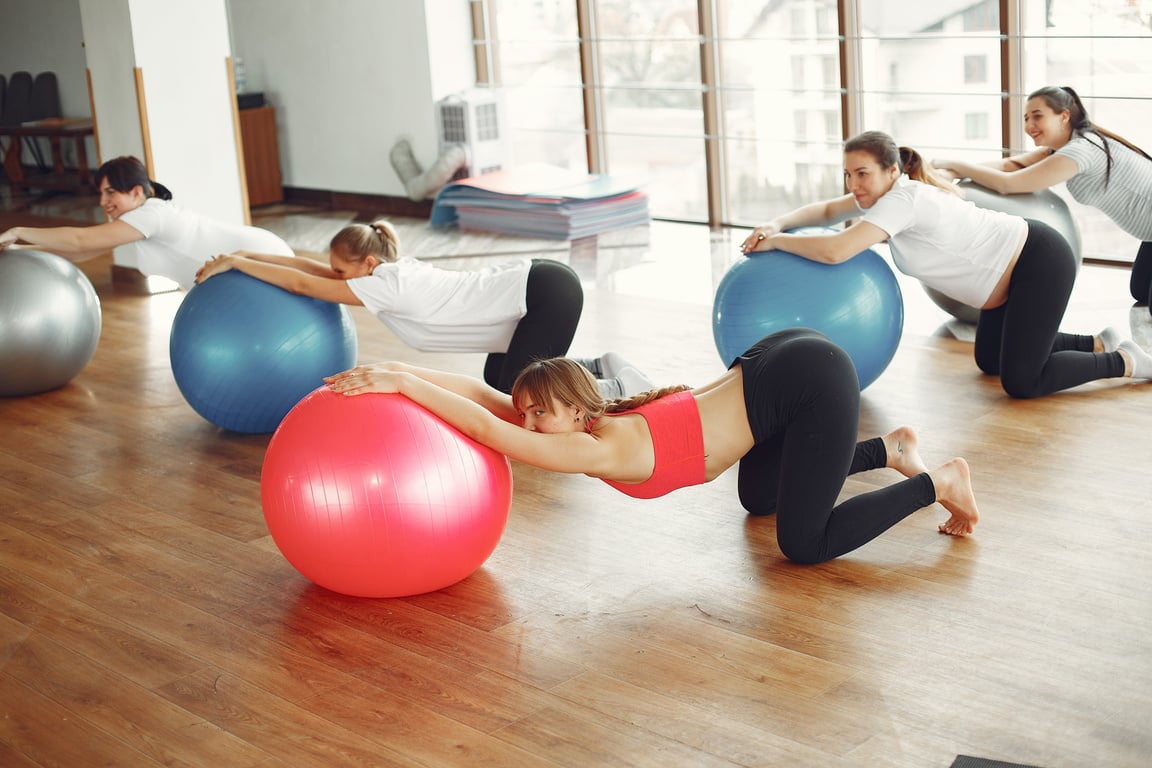 Pregnancy group practicing with fit ball in fitness class