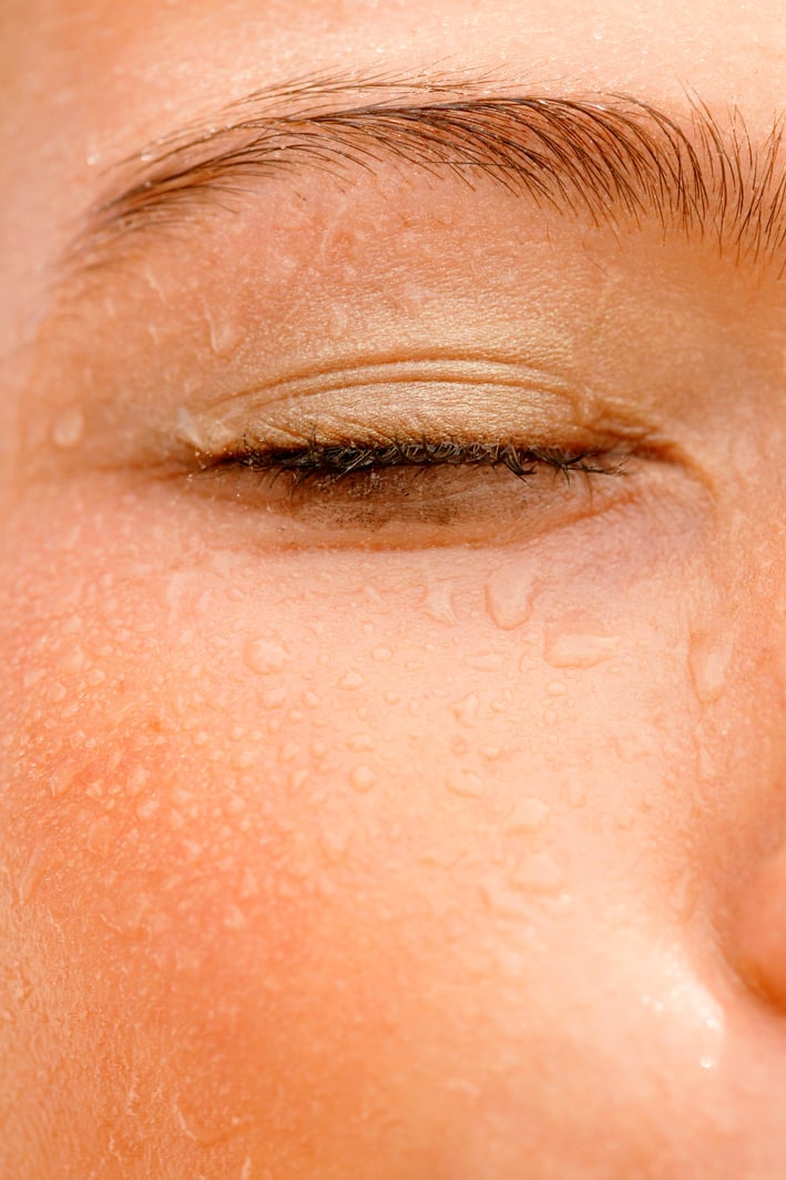 Sweat dripping down eye of woman